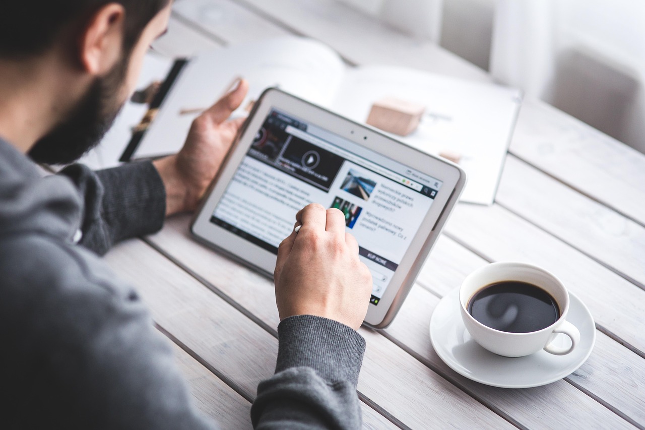 Man, reading, touchscreen — Andrew Hillman Enabling Companies to Navigate Challenges and Achieve Goals